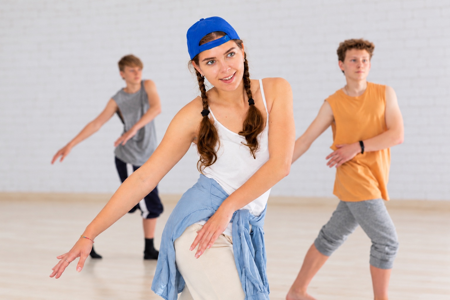 Drei Jugendliche bei einer Commercial-Choreografie im hellen Tanzstudio