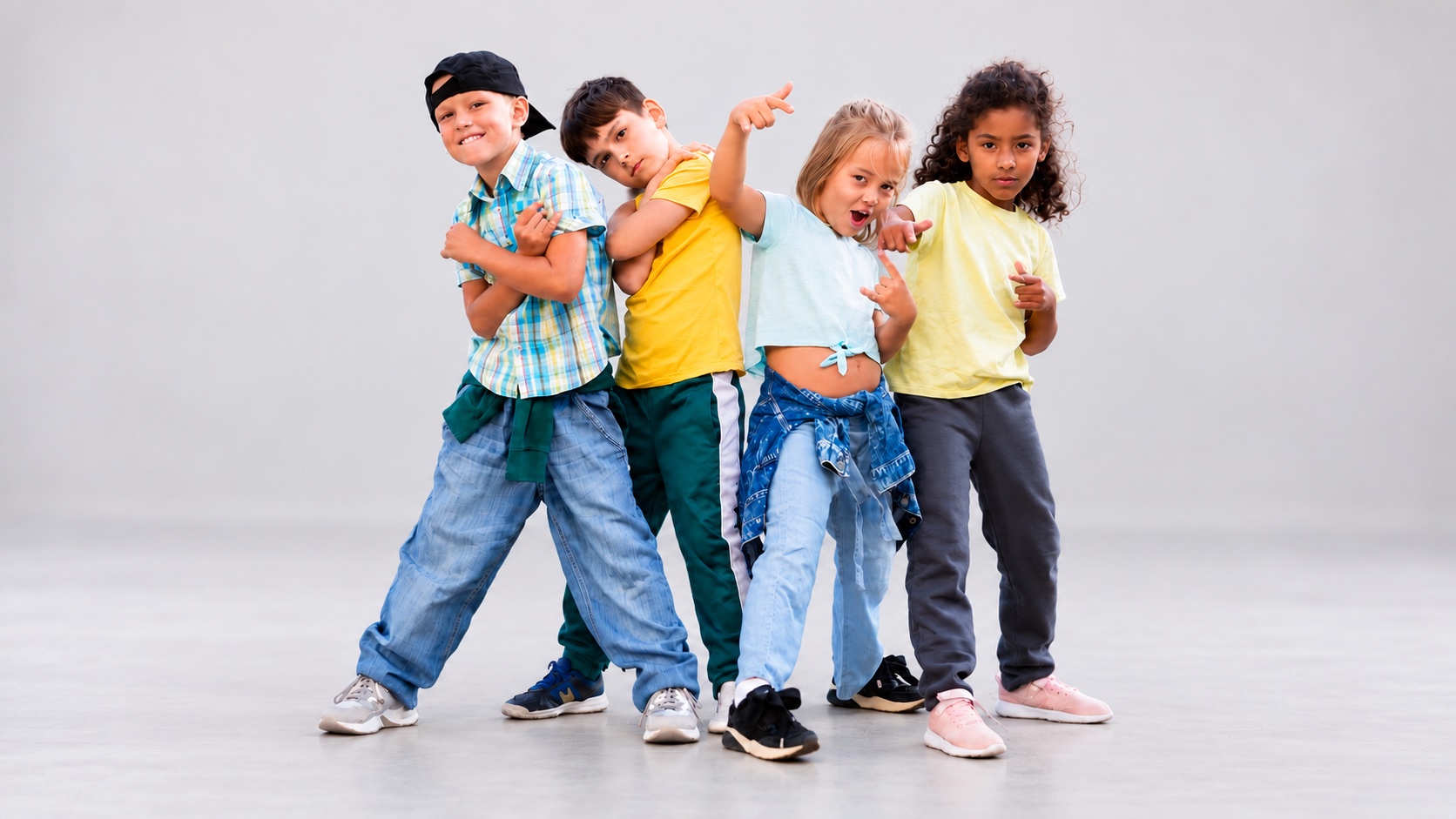 Vier Kinder in Hip-Hop-Posen vor einem hellgrauen Hintergrund